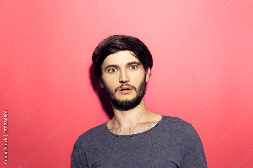 Portrait of young surprised man on pink coral background. Portrait of young surprised man on pink coral background.