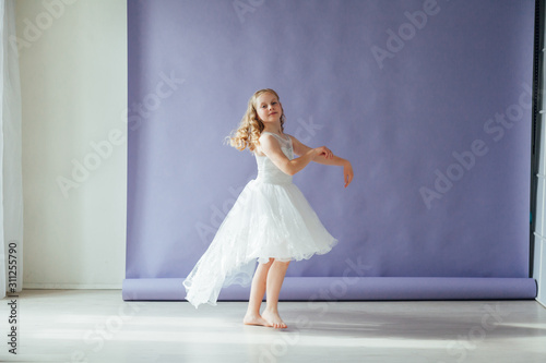 Beautiful little girl blonde dancing to music