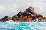 Rock in the ocean on a background of the cloudy sky, Galapagos Island, Isla Isabela.