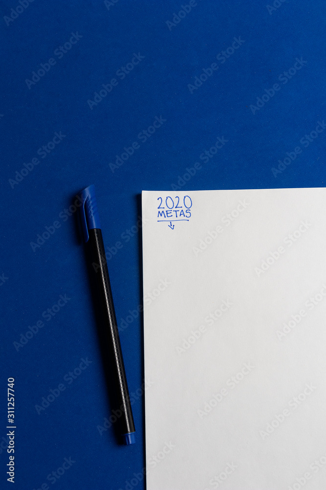 Lapicero negro con azul sobre escritorio azul clásico con hoja de papel  listo para las metas 2020 en español escrito con tinta azul Stock Photo |  Adobe Stock