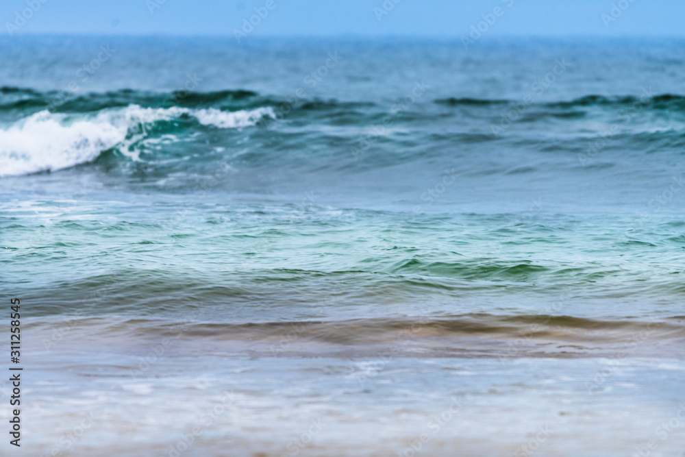 Raudasandur or red sandy beach in the westfjords of Iceland. Green and bluish waves are crashing ashore. Ocean, traveling concept.