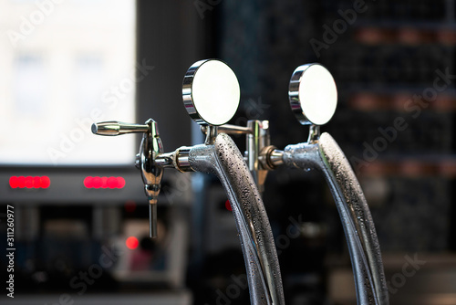 Close-up of shiny beer tap over unfocused background at brewery bar.