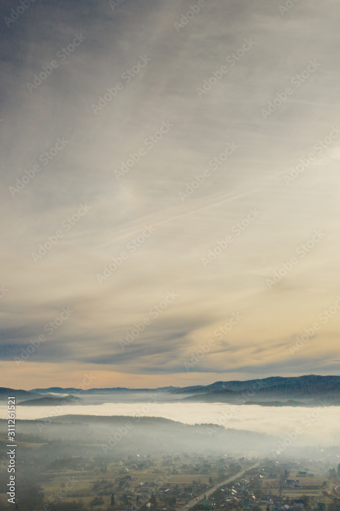 Fog in mountains before sunrise, mountain valley with clouds. View to mountains of the Carpathians