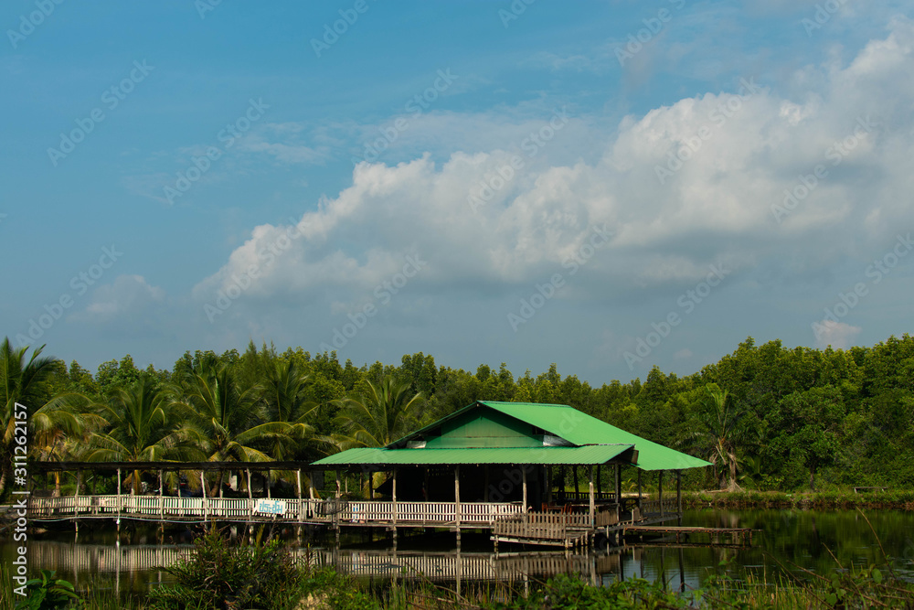 A traditional house with a jetty built over a lake in thailand A traditional house with a jetty built over a lake in thailand