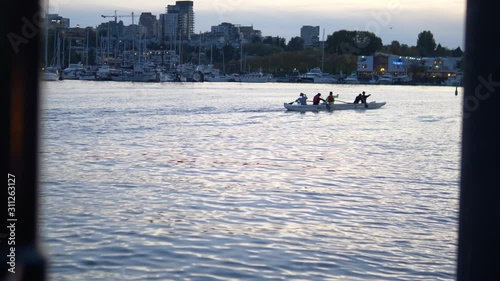slow motion team paddling boat on the water photo