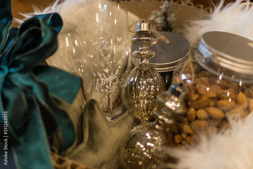 Elegante pacco natalizio con vaso di mandorle, decorazioni natalizie e bicchieri di Champagne