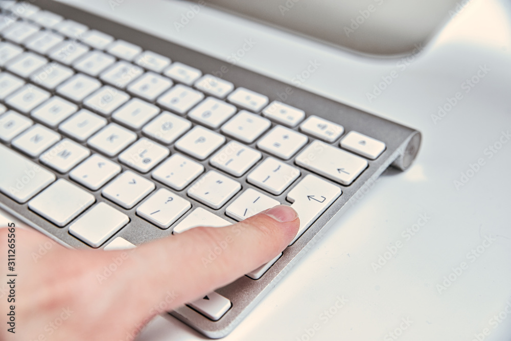 Pressing the enter key on the keyboard. The concept of accepting a contract, sending data, buying online. Man presses the ENTER key on the keyboard in the home office. Pressing the enter key on the keyboard. The concept of accepting a contract, sending data, buying online. Man presses the ENTER key on the keyboard in the home office.