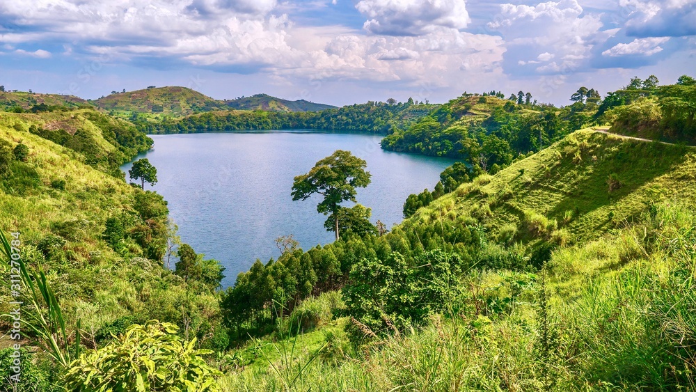The lush, green, fertile landscape surrounding Lake Nyinambuga, an ancient volcanic caldera filled with water, part of the crater region in western Uganda.
