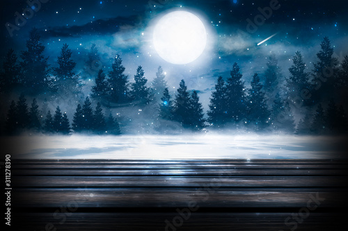 Dark winter background. Wooden table top in the foreground, winter landscape with bokeh in the background © MiaStendal