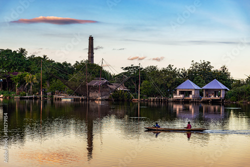 View of roral people with boat in river and sunset countryside photo