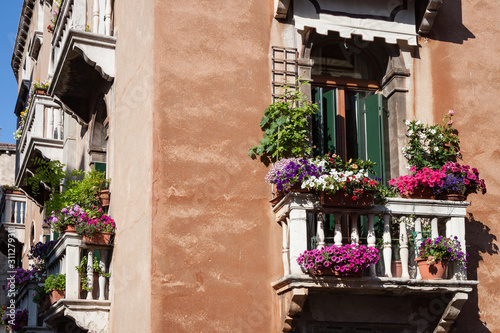 Fototapeta Naklejka Na Ścianę i Meble -  Balconies in Venice Covered With Flowers in Apartment Building