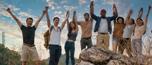 group of diversity people having fun together climbing up rocky mountains to the peak photo