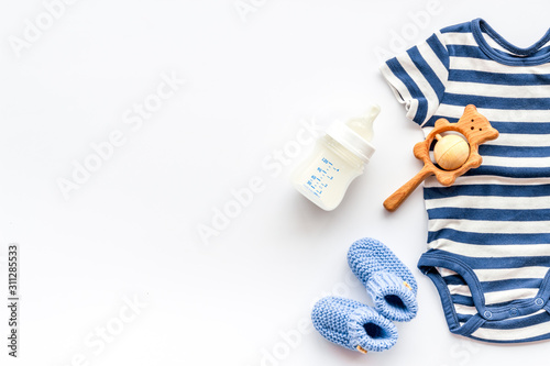 Baby background - blue color. Clothes and accessories for newborn boy on white table top-down frame copy space
