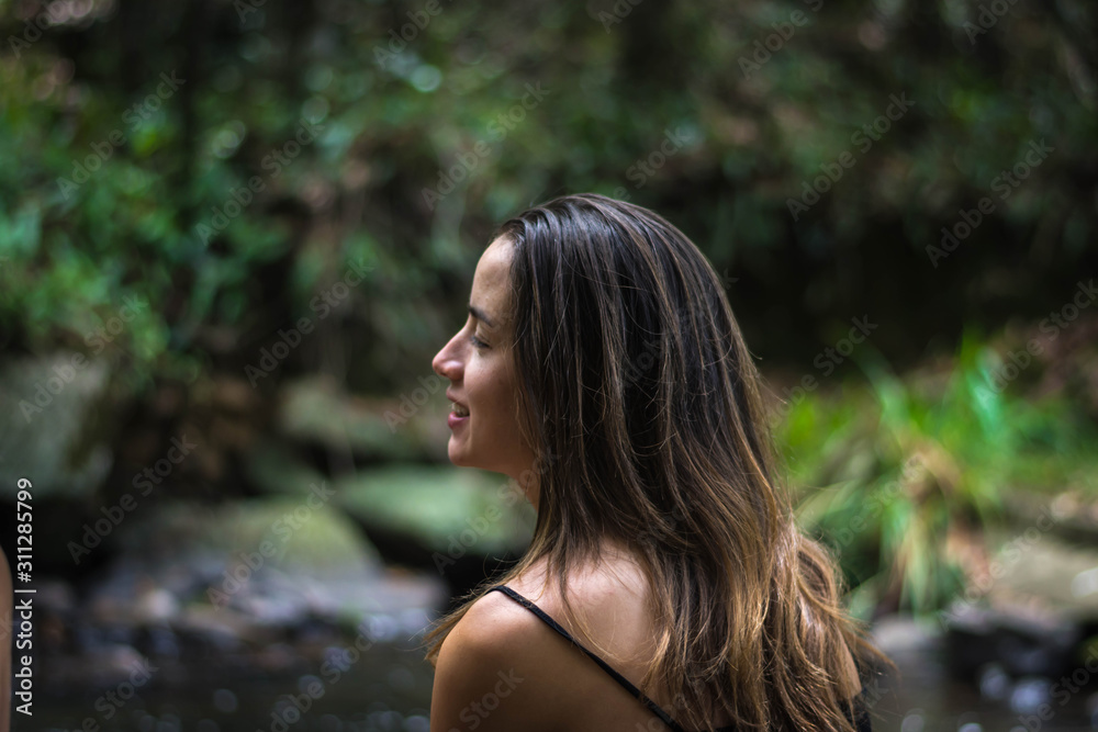 Beautiful young woman with long hair smiling in nature