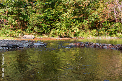 A calm pool of water created by humans to slow down the water flow and allow the gathering of macro invertebrates by the students. Horizontal, landscape orientation.