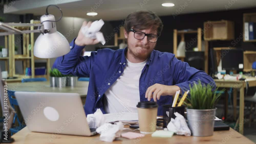 Young businessman signs a document and then throws it away Young businessman signs a document and then throws it away