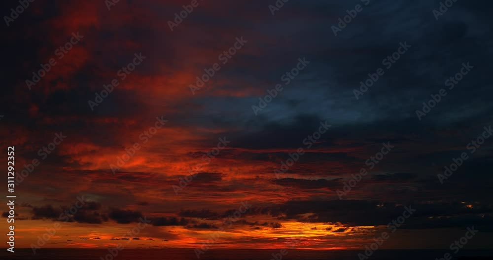 Ocean panorama. Dark orange clouds day to night sky. Dramatic sunset over storm clouds. Beautiful red color sky. Red purple orange blue pink sunset cloud background. Concept holiday in the tropics. Ocean panorama. Dark orange clouds day to night sky. Dramatic sunset over storm clouds. Beautiful red color sky. Red purple orange blue pink sunset cloud background. Concept holiday in the tropics.