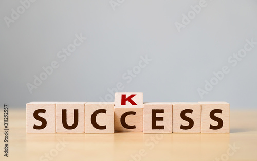 Wooden cube block flip over with word suck to success. Concept of successful in business