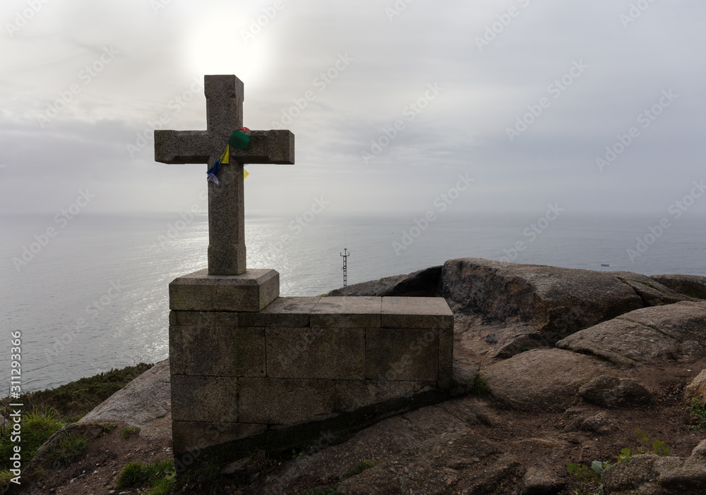 The end of the pilgrimage route in northeastern Spain on the Atlantic Ocean. A stone cross symbolizes the target point. The high cliffs near the town of Finisterre. The end of the pilgrimage route in northeastern Spain on the Atlantic Ocean. A stone cross symbolizes the target point. The high cliffs near the town of Finisterre.