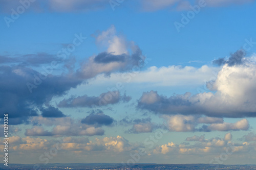 Bild auf Leinwand Cloudy sky with a parts of clear blue sky on a sunset over the land