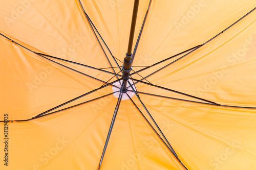 Interior view of a yellow umbrella: ribs and tent