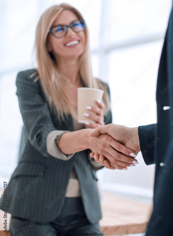 young businesswoman with a Cup of coffee welcomes her colleague young businesswoman with a Cup of coffee welcomes her colleague