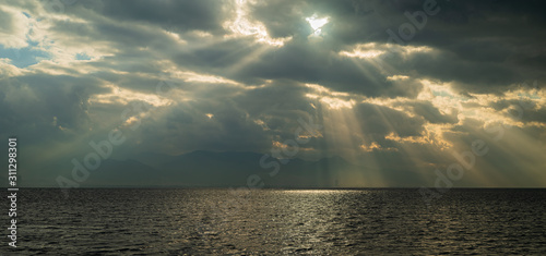 Lights falling into the city among the clouds. Dance of lights in Izmir Bay. ...