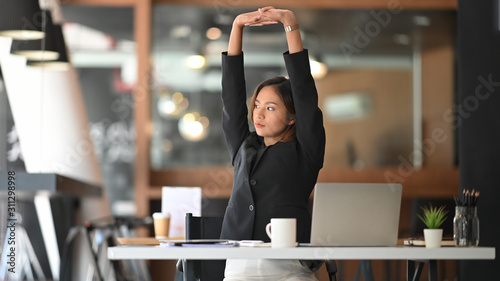Businesswoman relaxing at comfortable in office hands behind head, happy woman resting in office satisfied after work. photo