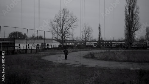 BW Shot of Man Looking at Abandoned Old Rusty Train Wagons on Railwa 4k