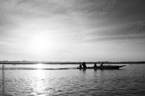Thai wooden boat travel in peaceful Nong Harn lake - Udonthani  Thailand. Famous red lotus lake in winter