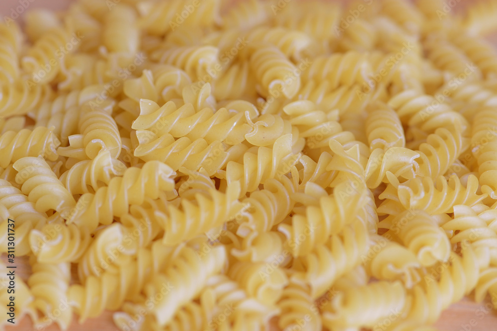 Scattered macaroni on a wooden surface close-up. Food background Scattered macaroni on a wooden surface close-up. Food background