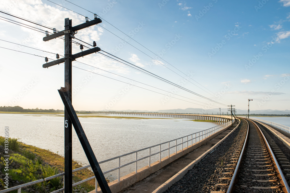 Landscape View of  Train crossing Pasak Chonlasit Dam. Reservoir for agriculture at Lopburi,Thailand