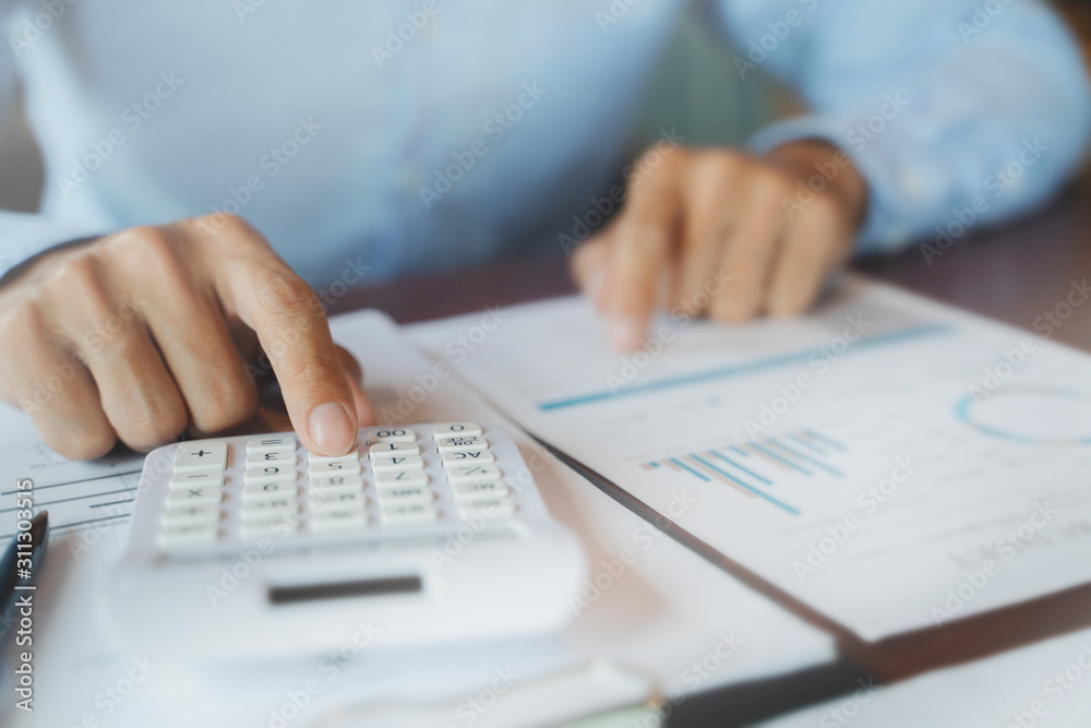 Business executive calculating a sales data perform spreadsheets. Business executive calculating a sales data perform spreadsheets.