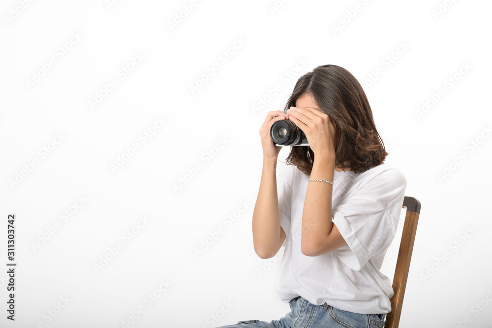 Young woman holding camera up covered face looking in lens on white background, Isolated, Thailand Young woman holding camera up covered face looking in lens on white background, Isolated, Thailand