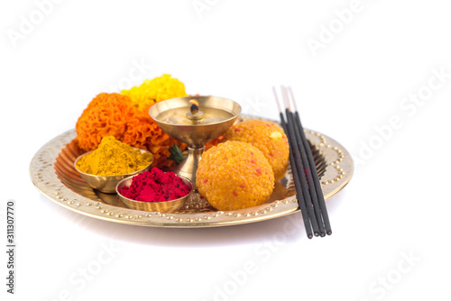 Beautifully Decorated Pooja Thali for festival celebration to worship, haldi or turmeric powder and kumkum, flowers, scented sticks in brass plate, hindu puja thali