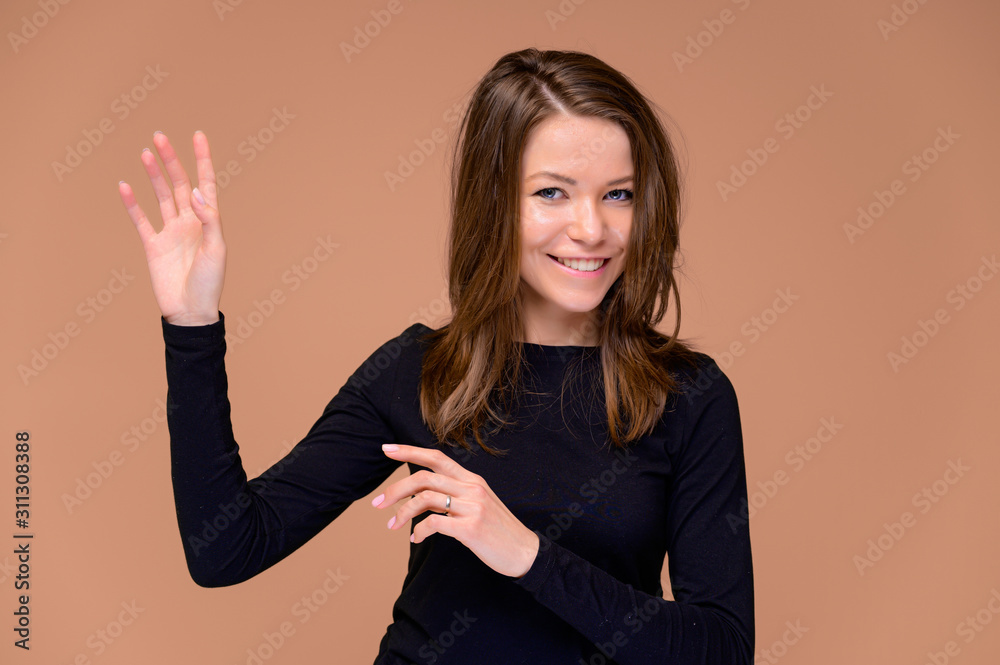 Concept of a young woman with a white-toothed smile. Close-up Portrait of a cute girl in a black T-shirt with beautiful teeth. Smiling, showing emotions on a pink background. Concept of a young woman with a white-toothed smile. Close-up Portrait of a cute girl in a black T-shirt with beautiful teeth. Smiling, showing emotions on a pink background.