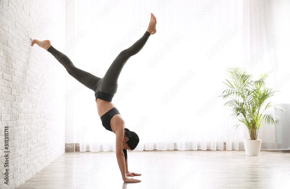 Young woman practicing downward facing tree asana in yoga studio. Adho Mukha Vrksasana pose Young woman practicing downward facing tree asana in yoga studio. Adho Mukha Vrksasana pose