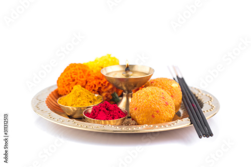Beautifully Decorated Pooja Thali for festival celebration to worship, haldi or turmeric powder and kumkum, flowers, scented sticks in brass plate, hindu puja thali