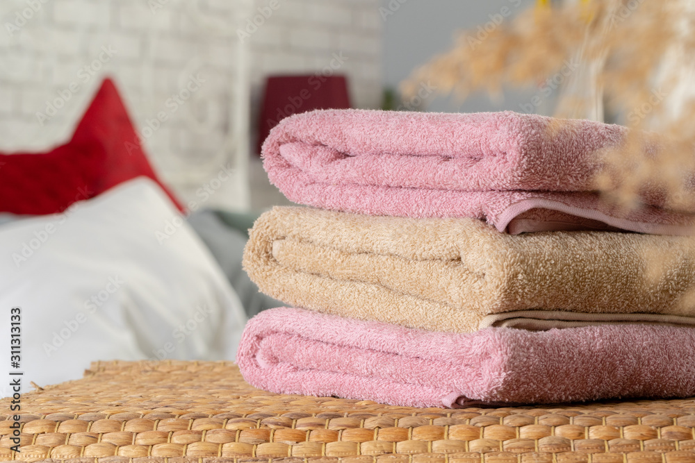 Premium Photo  Stack of clean towels on wooden table in bedroom