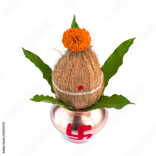 Copper Kalash with coconut and mango leaf with floral decoration on a white background. Essential in Hindu Puja.