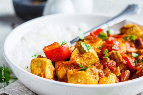 Jalfrezi chicken with rice in white bowl. Traditional indian cuisine concept.