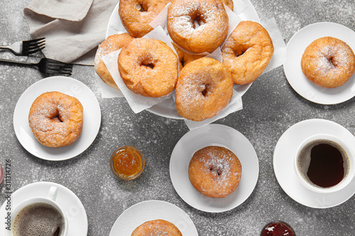 Sweet tasty donuts and coffee on grey background