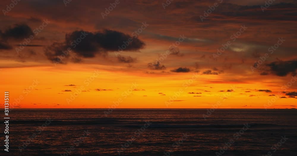 Tropical beach. Dark orange clouds day to night sky reflected in big waves crushing coast. Beautiful dramatic sunset sky. Red purple orange blue pink sunset cloud background. Ocean surfer lifestyle. Tropical beach. Dark orange clouds day to night sky reflected in big waves crushing coast. Beautiful dramatic sunset sky. Red purple orange blue pink sunset cloud background. Ocean surfer lifestyle.