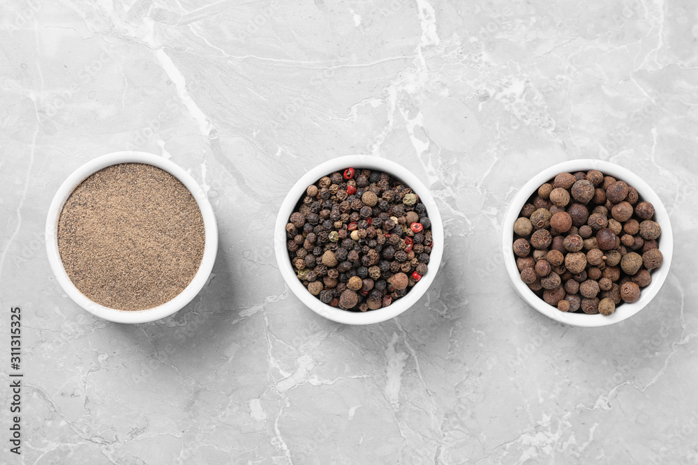 Ground pepper and corns on grey table, flat lay Ground pepper and corns on grey table, flat lay