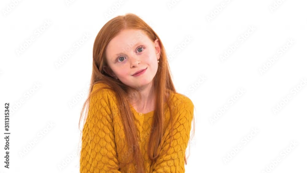 Portrait shot of a lovely little girl with long foxy hair and freckles with unpleased face expression posing at camera. Isolated, on white background Portrait shot of a lovely little girl with long foxy hair and freckles with unpleased face expression posing at camera. Isolated, on white background