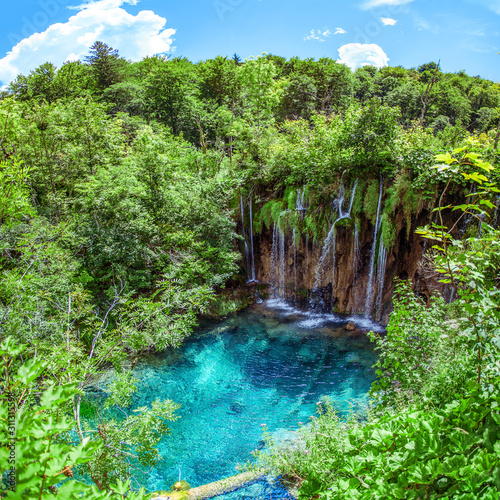 Plitvicer Lakes  Croatia  A beautiful  refreshing waterfall that flows into a turquoise lake surrounded by a dense green forest