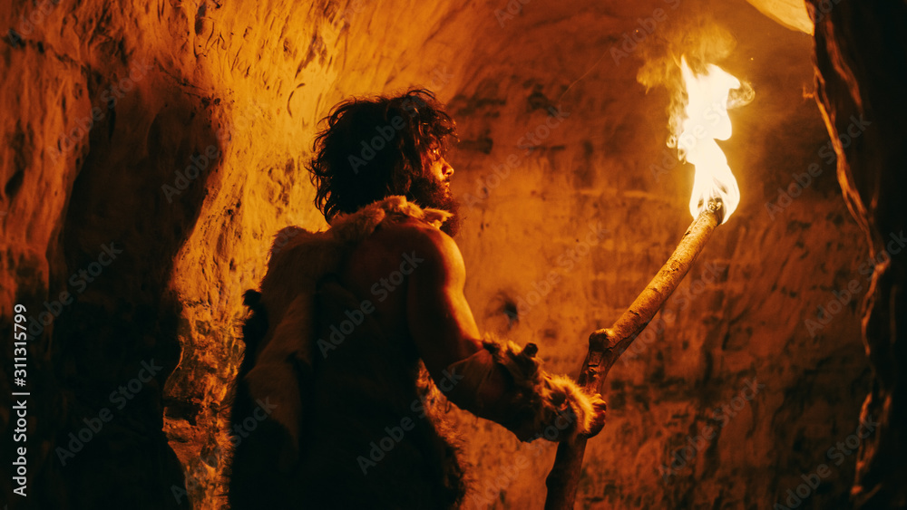Portrait of Primeval Caveman Wearing Animal Skin Exploring Cave At