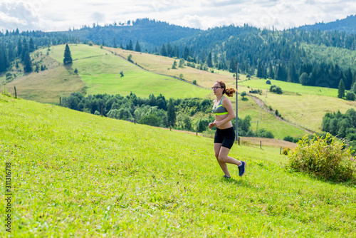 Healthy lifestyle woman trail runner running on mountain peak.