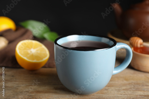 Cup of delicious hot tea on wooden table