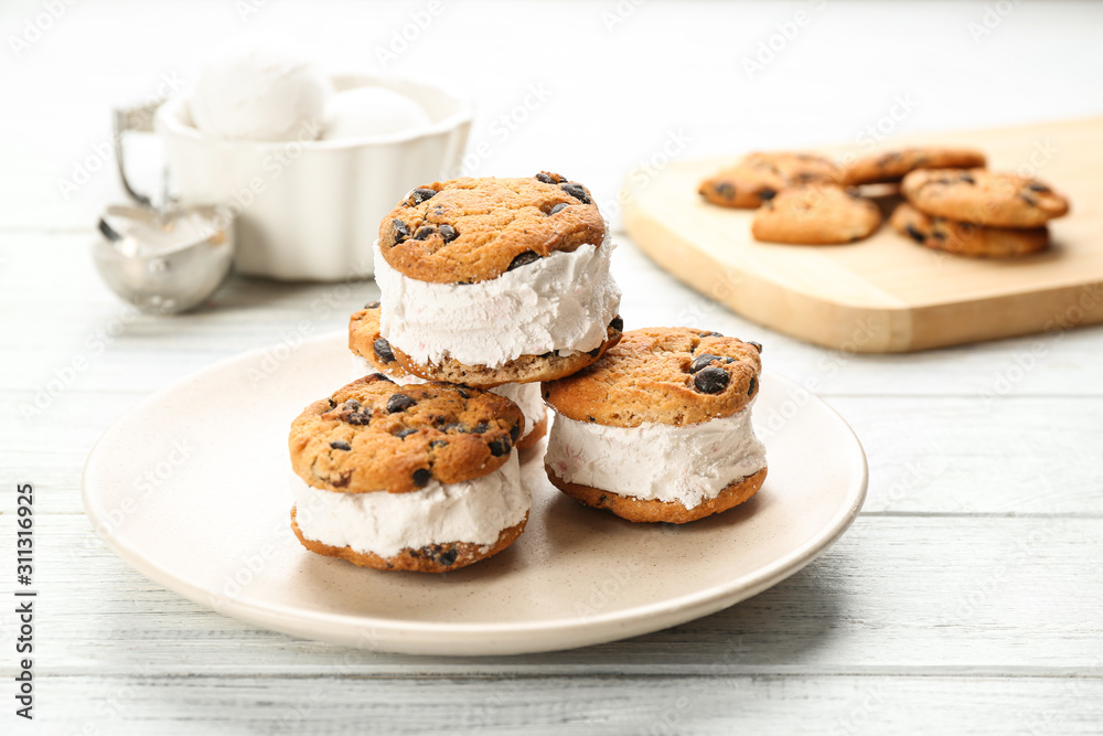 Sweet delicious ice cream cookie sandwiches on white wooden table